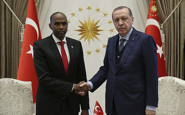 Le président turc Recep Tayyip Erdogan (à droite) et le Premier ministre somalien Hassan Ali Khayre se serrent la main lors d'une cérémonie de bienvenue à Ankara, en Turquie, le jeudi 26 octobre 2017. M. Khayre rend visite aux victimes de l'attentat au camion piégé de Mogadiscio, soignées en Turquie. (Crédit : Service de presse présidentiel, photo de groupe via AP) Le président turc Recep Tayyip Erdogan (à droite) et le Premier ministre somalien Hassan Ali Khayre se serrent la main lors d'une cérémonie de bienvenue à Ankara, en Turquie, le jeudi 26 octobre 2017. M. Khayre rend visite aux victimes de l'attentat au camion piégé de Mogadiscio, soignées en Turquie. (Crédit : Service de presse présidentiel, photo de groupe via AP)