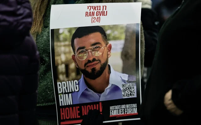 Une affiche du sous-officier de l'unité d'élite de police Yassam Ran Gvili visible lors d'un rassemblement appelant le Hamas à restituer sa dépouille, toujours retenue à Gaza, dans la communauté israélienne de Meitar, au sud du pays, le 13 décembre 2025. (Crédit : Tsafrir Abayov/Flash90) Une affiche du sous-officier de l'unité d'élite de police Yassam Ran Gvili visible lors d'un rassemblement appelant le Hamas à restituer sa dépouille, toujours retenue à Gaza, dans la communauté israélienne de Meitar, au sud du pays, le 13 décembre 2025. (Crédit : Tsafrir Abayov/Flash90)
