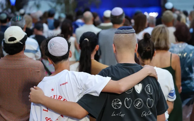 Des personnes venues rendre hommage lors de la cérémonie commémorative organisée une semaine après la tuerie terroriste qui a visé un événement juif à Bondi Beach, à Sydney, le 21 décembre 2025. (Crédit : David Gray/AFP)