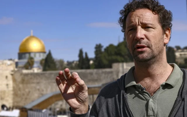 L'historien français Vincent Lemire parle lors d'une interview près du mur occidental, avec une vue sur la mosquée du Dôme du Rocher, sur le mont du Temple, à Jérusalem, le 25 janvier 2022. (Crédit : Ronaldo Schemidt / AFP)