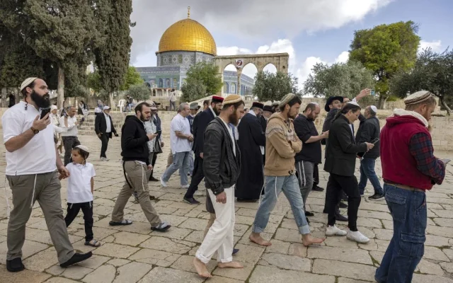 Un groupe de Juifs religieux devant le Dôme du rocher pendant leur visite sur le mont du Temple dans la Vieille Ville de Jérusalem, le 20 avril 2022. (Crédit : Menahem Kahana / AFP)