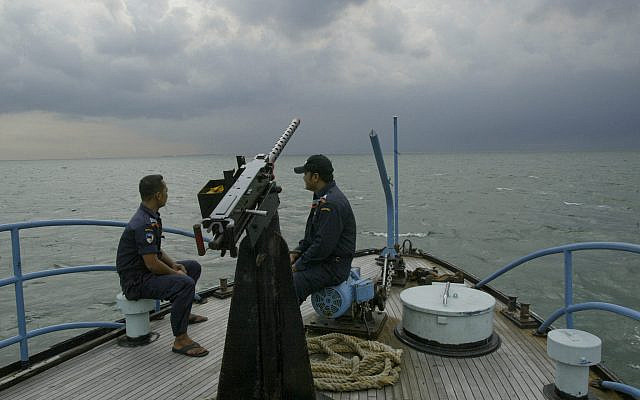 Des garde-côtes indonésiens sont assis sur le pont de leur patrouilleur, sillonnant les eaux du détroit de Malacca (photo d'archives du 26 mai 2004). Après les attentats terroristes du 11 septembre 2001, le spectre de la piraterie planait sur le détroit de Malacca, l'une des voies maritimes les plus fréquentées au monde. Quatre ans et demi plus tard, le renforcement des mesures de répression par les pays riverains a contribué à contenir la menace de la piraterie, selon les analystes. (Crédit : AP/Ed Wray)