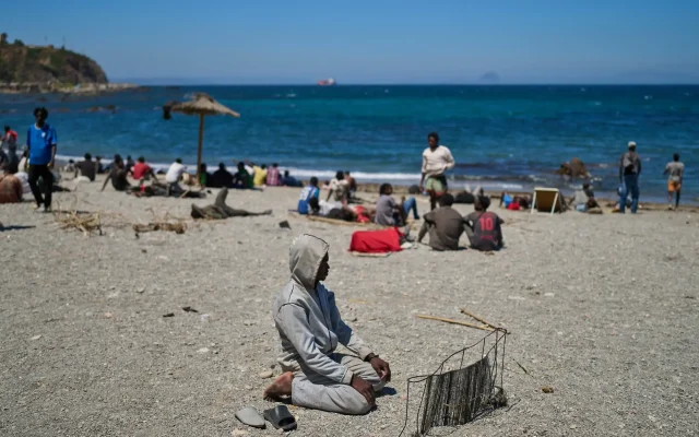 Un migrant ayant traversé depuis le Maroc vers l'Espagne prie sur une plage de l'enclave espagnole de Ceuta, le 2 août 2026. (Photo AP/Bernat Armangue)