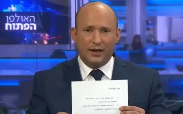 Naftali Bennett brandit un engagement signé de ne pas servir dans un gouvernement dirigé par Yair Lapid, le 21 mars 2021. (Capture d'écran/20ème chaîne)