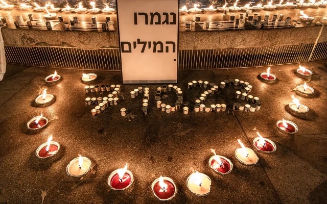 Une scène de la veillée de plus d'un millier de bougies sur le Kikar Dizengoff, à Tel Aviv, le 12 octobre 2023. La pancarte indique "Plus de mots". (Crédit : Eli Katzoff)