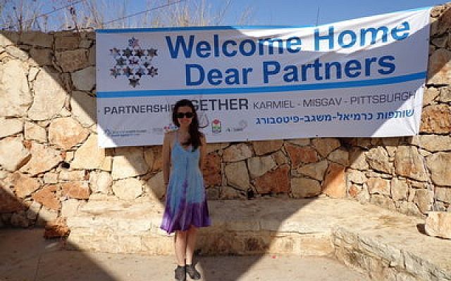Abby Gordon stands in front of a banner welcoming Pittsburgh's Partnership 2gether partners to Mt. Arbel in the Misgav Region