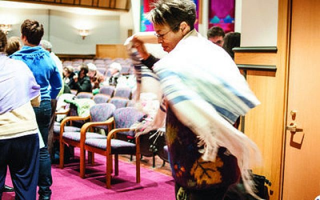 Esther Chaya Batsarah of Swissvale wraps herself in a tallit, Sunday, Oct. 28, at Rodef Shalom Congregation before she and more than 100 others protest the arrest of Anat Hoffman at a “Shema-in.” Hoffman was arrested Oct. 16 for reciting the Shema at the Western Wall in Jerusalem. Female attendees at the Shema-in wore tallitot to support Hoffman and her organization, Women at the Wall. (Chronicle photos by Lindsay Dill)