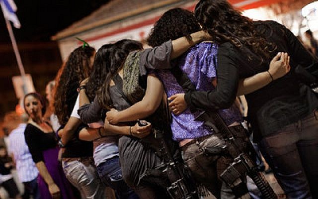 Israeli girls wear automatic rifles as they dance together during a celebration. (Marco Longari/AFP/Getty Images)