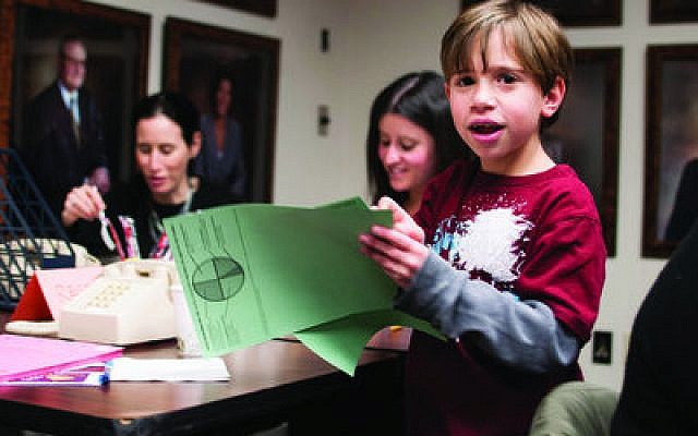 Jonah Keller, 8, of Squirrel Hill, collects completed donor sheets from Fundfest volunteers. This is his second year participating in the annual communal fundraising event. (Chronicle photos by Lindsay Dill)