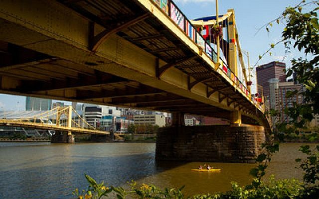 Two kayakers on the Allegheny River get a unique view of the yarn-bombed Andy Warhol Bridge. Thanks to 1,000-plus volunteers, the landmark span is draped in fiber tapestries in a pubic art exhibit that is attracting national attention. (Chronicle photos by Ralph Musthaler)