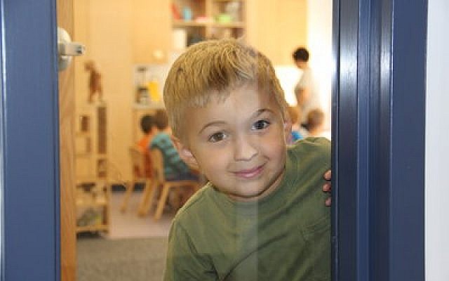 Dominic Morrow looks inquisitively through the window of his classroom at the Jewish Community Center’s new Annabelle Rubinstein Early Childhood Development Center, which officially opened this week. (Jewish Community Center of Greater Pittsburgh photo)