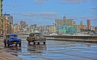 Old American cars are a Cuban staple. Here they drive on a road bordering Havana Bay. (Marla Whitesman/photo illustration)