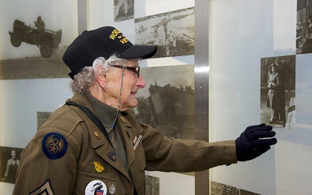 An unidentified woman who served in the Army during World War II studies a photo of her with her husband on the wall of the new World War II memorial on the North Shore. She became overwhelmed with emotion at the sight of the image. (Craig Collins photo)