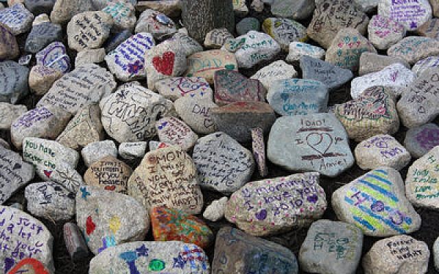 Above, Circle Campers inscribe rocks with messages to their deceased parents, which they then place in “memory gardens.” Circle Campers participate in the same kinds of activities as any other camper, including jumping en masse into a lake.  (Photos courtesy of Sandi Lando Welch)