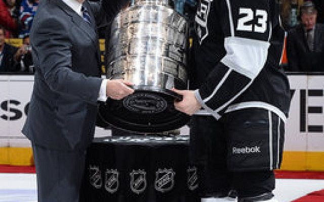 NHL Commissioner Gary Bettman (left) presents Dustin Brown of the Los Angeles Kings with the Stanley Cup at the Staples Center last June. (Photo by Andrew D. Bernstein/NHLI via Getty Images)