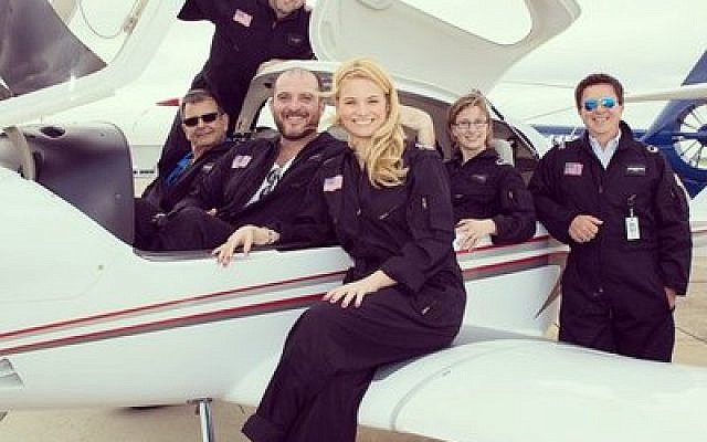 Co-founder Brad Childs (in back, standing) poses with his Pittsburgh Aviation Animal Rescue Team. The group flies to areas in Pennsylvania, Ohio and West Virginia to save animals in distress or danger. (Photo by Bee Schindler)