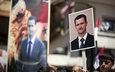 In April 2012, Druze residents of Israel’s Golan Heights hold Syrian flags and portraits of Syrian President Bashar al-Assad during a rally in the Druze village of Majdal Shams to mark the Syrian Independence Day. (Photo by Matanya Tausig/Flash90)