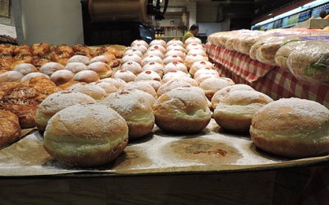 Sufganiyot on display in Jerusalem’s Central Bus Station. The jelly doughnut began appearing in bakeries around Israel more than a month before Chanukah. (Photo by Ben Sales)