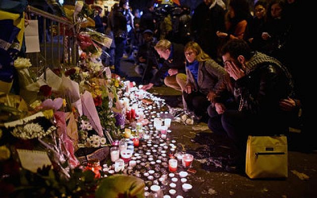 People place flowers and candles near the scene of the Bataclan Concert Hall terrorist attack in Paris. (Photo by Jeff Mitchell/Getty Images)
