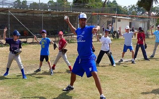 Nate Fish, director of the Israel Association of Baseball, demonstrates proper pitching motion to Israeli kids. (Photo by Margo Sugarman/IAB)