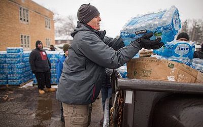 Volunteers load cases of free water into waiting vehicles at a water distribution center in Flint, Mich.

Photo by Geoff Robins/AFP/Getty Images