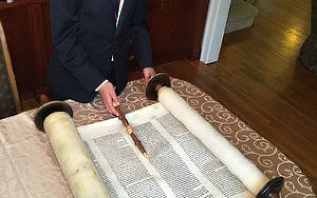 Reuven Kanal reads from the Torah that belonged to his great-great-grandfather, who buried it before World War II. 

Photo courtesy of Dr. Emanuel Kanal