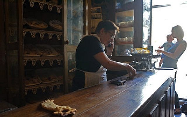 Herminia Rodriguez prepares change for a customer at her Jewish bakery in Ribadavia, Spain.	Photo by Cnaan Liphshiz