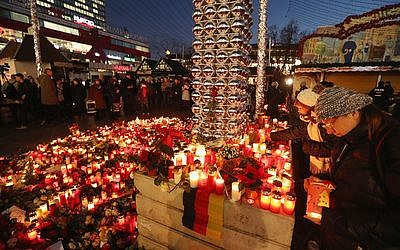 Mourners place flowers and candles at a makeshift memorial in Berlin near the site where suspect Anis Amri drove a heavy truck into a Christmas market in an apparent terrorist attack. 

Photo by Sean Gallup/Getty Images