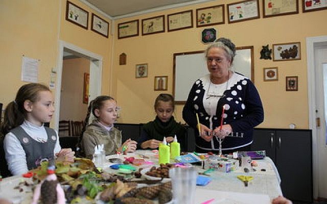 Irina Shlaeva, a social worker of Moldova’s Jewish Family Service, and her students lighting Chanukah candles in Chisinau last December. 	Photo courtesy of JDC