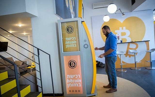 On Nov. 5, a man uses a bitcoin ATM machine at the Bitcoin Change center on Dizengoff Street in Tel Aviv. The center houses the ATM as well as a museum on the history of the cryptocurrency. (Photo by Miriam Alster / Flash90)