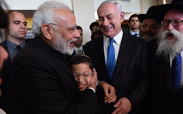 Indian Prime Minister, left, embracing 11-year-old Moshe Holtzberg, whose Chabad emissary parents were killed in a 2008 terror attack in Mumbai, with Israeli Prime Minister Benjamin Netanyahu on left in Israel, July 5, 2017 . (Photo by Haim Zach/Israeli Government Press Office)