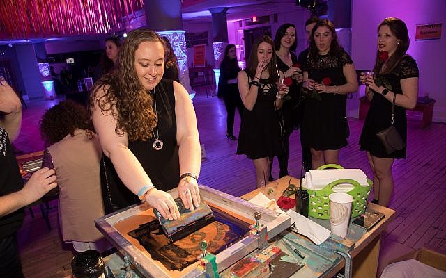 Rachel Wagner designed and silk-screened her own Shalom Pittsburgh-J’Burgh tote bag at the party. More than 160 young adults attended the event. (Photos by Joshua Franzos)