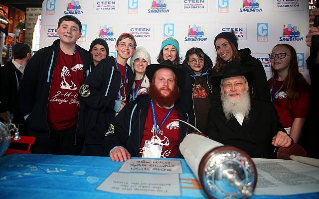 Chayale Denburg, standing second from right, and survivors of the Parkland, Fla., school shooting pose for a photo with Rabbi Shaya Denburg, seated left, and Rabbi Moshe Klein at Chabad’s CTeen conference. (Photo by Itzik Roytman/CTeen)