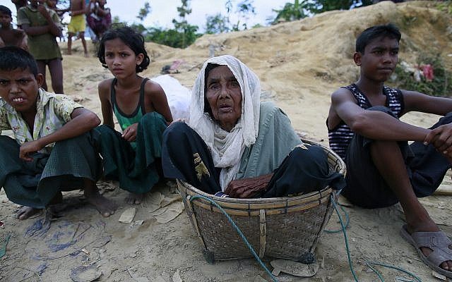 Rohingya Muslims, who crossed over from Myanmar into Bangladesh, sit beside a road in Ukniya, Bangladesh. (Photo by Suvra Kanti Das/iStockphoto)