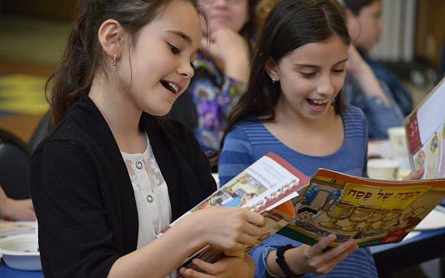 Fourth-grade students Roni Pishoto and Liron Ohayon sing the Four Questions at the CDS Intermediate School model seder. (Photo courtesy of Community Day School)