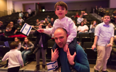 A father and son proudly wave Israeli flags during the Yom Ha'atzmaut celebration at the JCC in Squirrel Hill. (Photo by Josh Franzos)