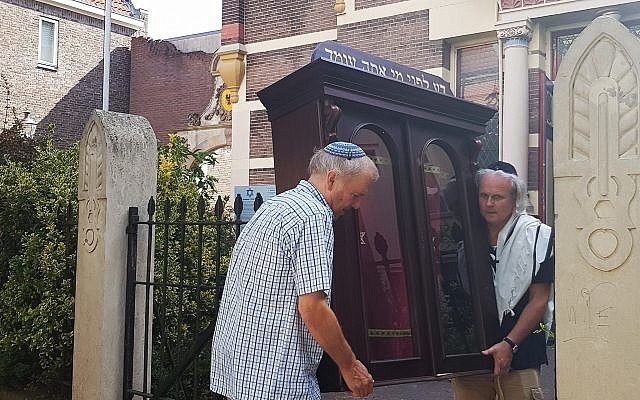 Tom Furstenberg, right, and a fellow congregant carry the Torah ark out of the Great Synagogue of Deventer last month. (Photo by Cnaan Liphshiz)