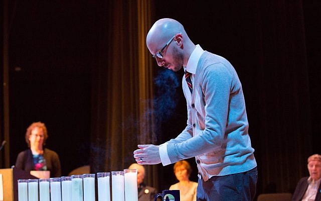 Nicholas Haberman, a teacher at Shaler Area High School, lights a candle at a Yom HaShoah commemoration. (Photo courtesy of the Holocaust Center of Pittsburgh)