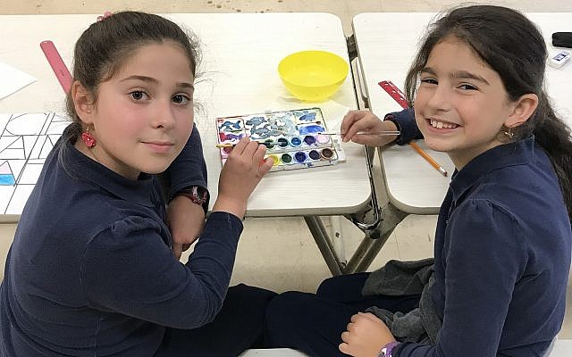 Fifth-graders Chana Katz and Perri Berelowitz bond over a mutual love of art and a shared watercolor palette. 	(Photo by Micki Myers)