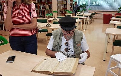Yoram Sztykgold examines the unpublished registry from 1939 that helped him locate his family’s assets at a military library in Warsaw, Sept. 4, 2018. (Photo by Cnaan Liphshiz)