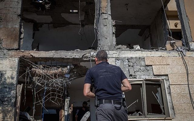 Israeli security forces survey a home hit by a rocket fired from the Gaza Strip in the southern Israeli city of Beersheba on Oct. 17, 2018. (Yonatan Sindel/Flash90)