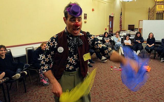 Nimi, a medical clown, tosses kerchiefs as Hillel Academy of Pittsburgh students laugh. (Photo by Adam Reinherz)