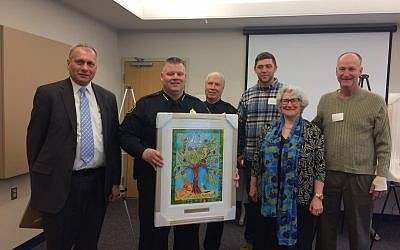 Rabbi Me’irah Iliinsky presents a framed print of “The Tree of Life is Weeping” to the Pittsburgh Police.  (Photo by Toby Tabachnick)