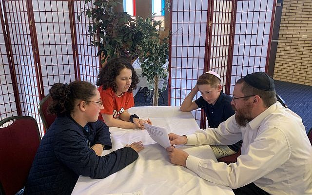 Rabbi Yisroel Altein tutoring Hallie, Samantha and Jack Cohen. Photo courtesy of Jed Cohen