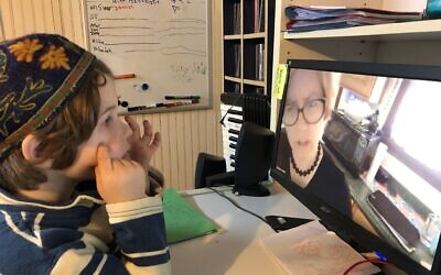 CDS Pre-K student Elihu Braasch participates in an online lesson with his teacher Liz Wolfe in the family basement that has been transformed into a classroom space.  Photo courtesy of Community Day School