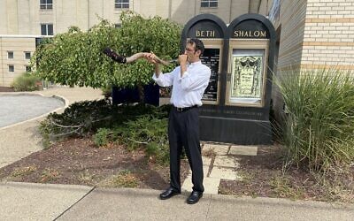 Congregation Beth Shalom's Rabbi Seth Adelson sounds a sock-covered shofar, while standing on Beacon Street in Squirrel Hill. Photo by Jim Busis