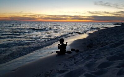 Malori Asman's grandson Riley Herman, now 8, throws rocks into the Gulf of Mexico at sunset for tashlich in Rosemary Beach, Florida in 2016. Photo by Erin Herman.