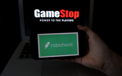 This photo illustration shows the logos of video grame retail store GameStop and trading application Robinhood in a computer and on a mobile phone in Arlington, Virginia on Jan. 28, 2021. (Photo by OLIVIER DOULIERY/AFP via Getty Images/via JTA)