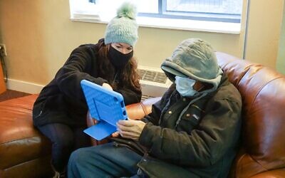 Nicole Iole, left, helps Frank, a JFCS ward, with his new iPad. Photo courtesy of JFCS