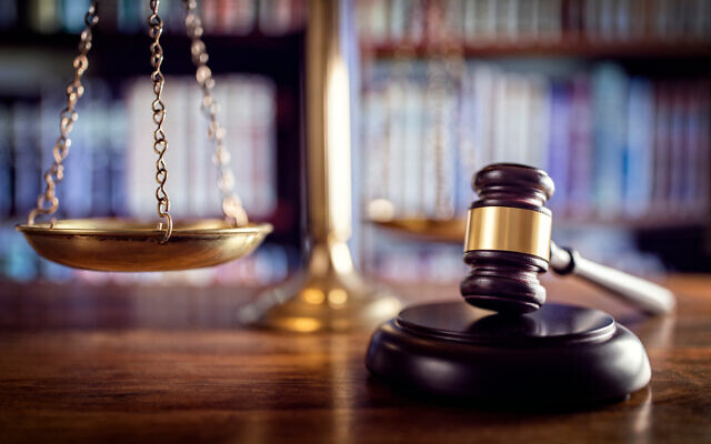 Judge gavel, scales of justice and law books in court. Photo by BrianAJackson via iStock